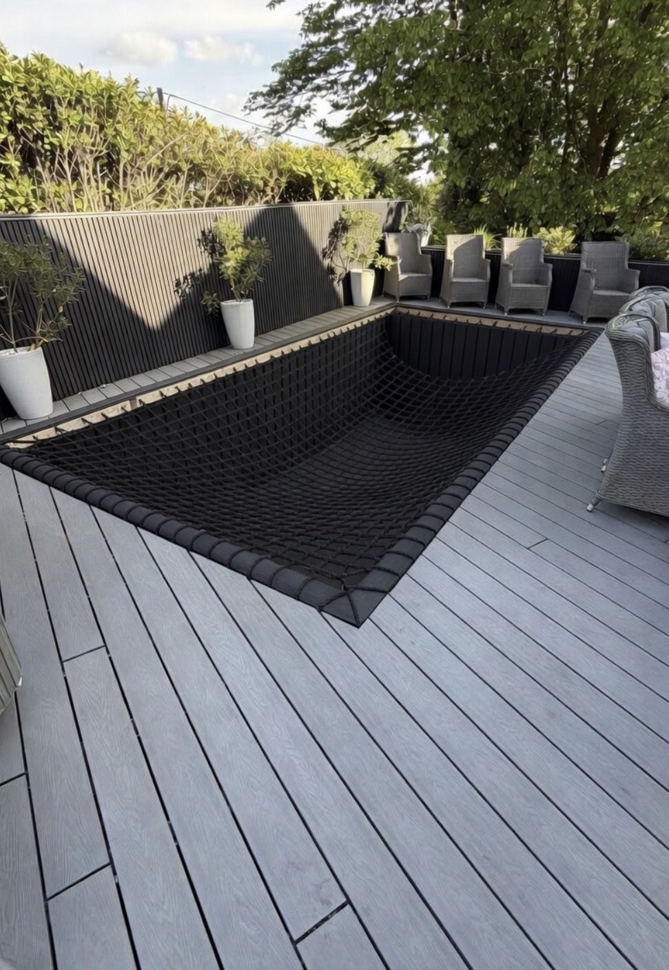 Dark slatted fence and composite deck with hammock net