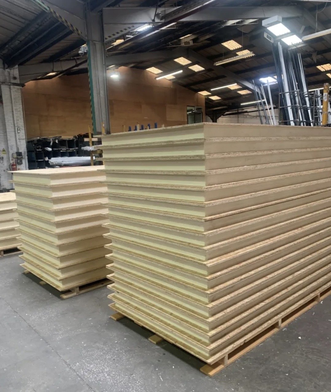 Two tall pallets of SIP panels in a warehouse